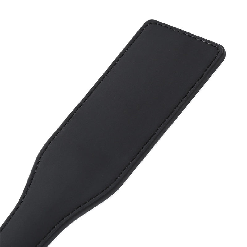 Black rectangular PU leather spanking paddle with stitched edges, shown diagonally on white