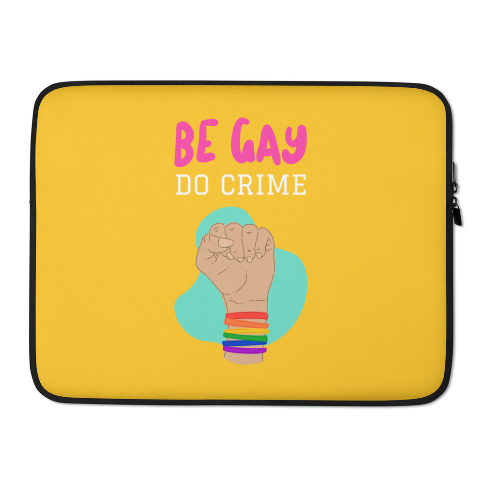 Yellow laptop sleeve with “BE GAY DO CRIME” text and a raised fist wearing rainbow bands