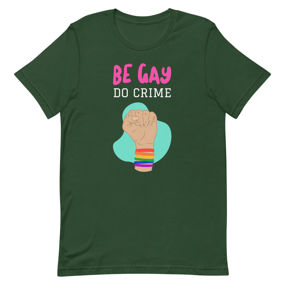 Front view of a dark green T-shirt reading “BE GAY DO CRIME” above a raised fist with rainbow bracelets