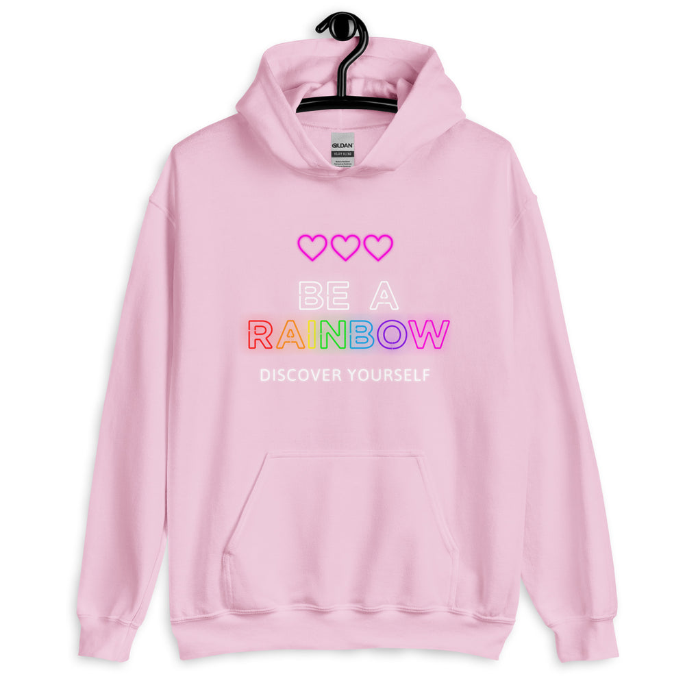 Front view of a light pink hoodie reading “BE A RAINBOW” and “DISCOVER YOURSELF.”