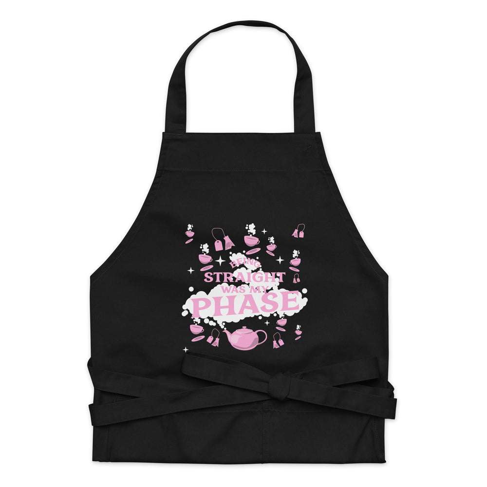 Black apron with pink-and-white “BEING STRAIGHT WAS MY PHASE” design and tea motifs