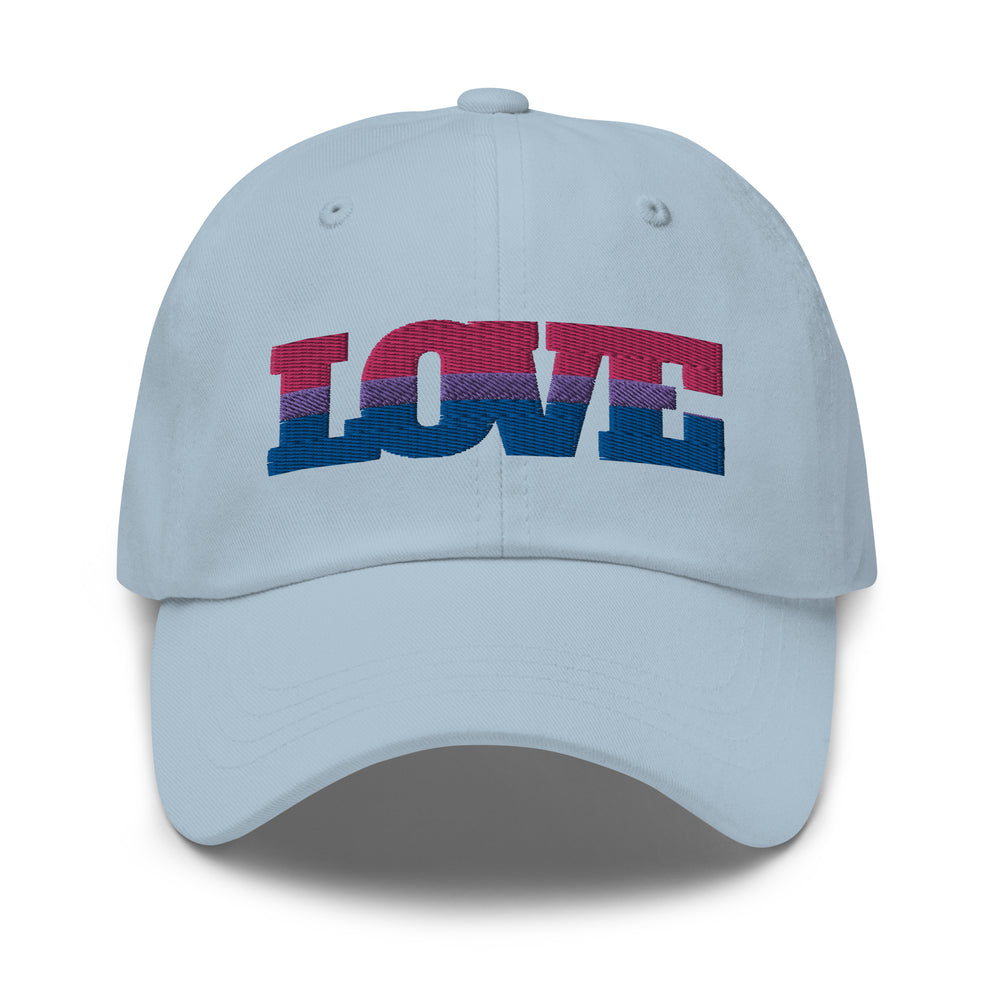 bi hats: Bisexual Love Cap: light blue pride hat with "LOVE" in bold pink, lavender, and blue. person, short curls, hoop