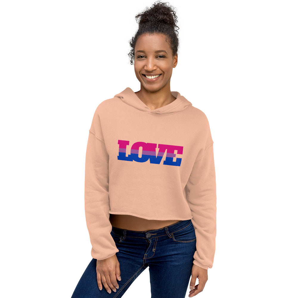 Front-view model wearing a peach cropped hoodie with a pink-and-blue LOVE graphic