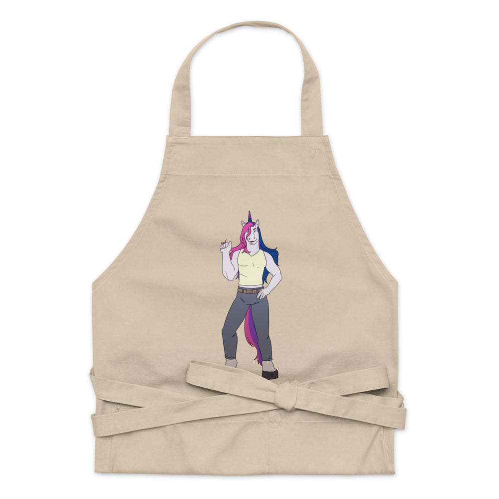 Front view of a beige apron with a colorful horned unicorn character and waist ties