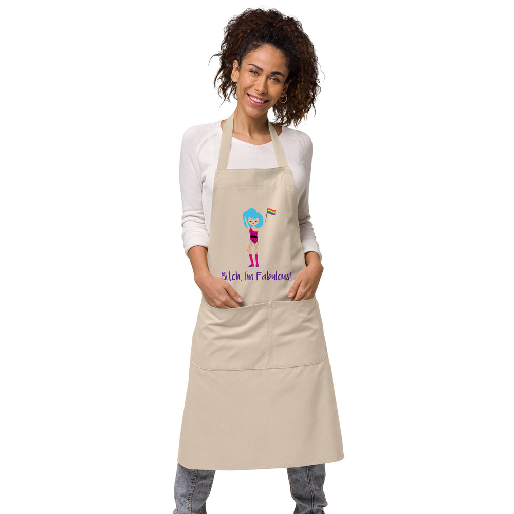 Front view of a beige apron worn by a smiling model, with a drag queen and rainbow flag graphic