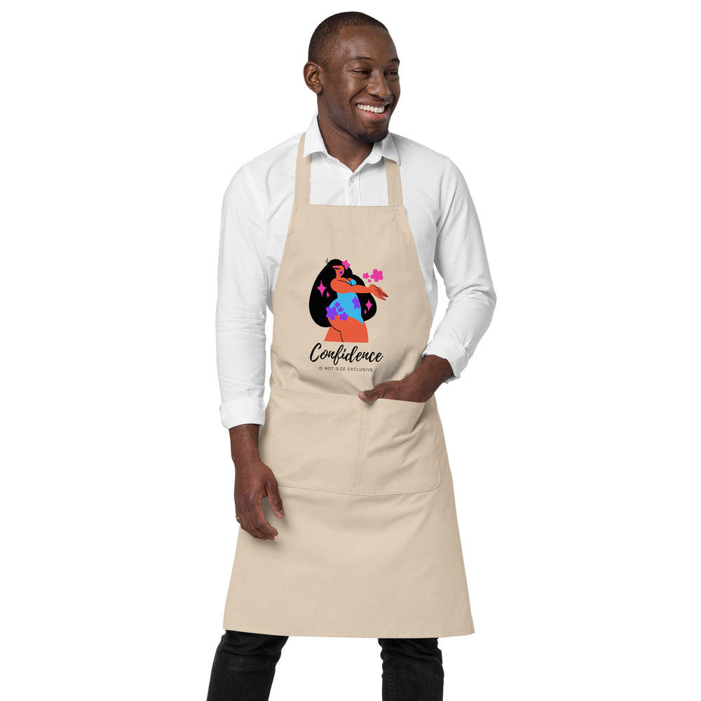 Model wearing a beige apron with a colorful figure and “Confidence” graphic, plus front pocket