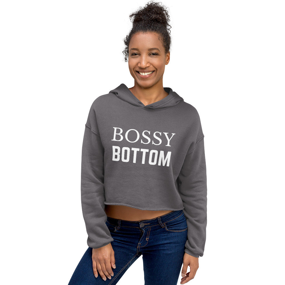 Front view of a model wearing a gray cropped hoodie reading “BOSSY BOTTOM”