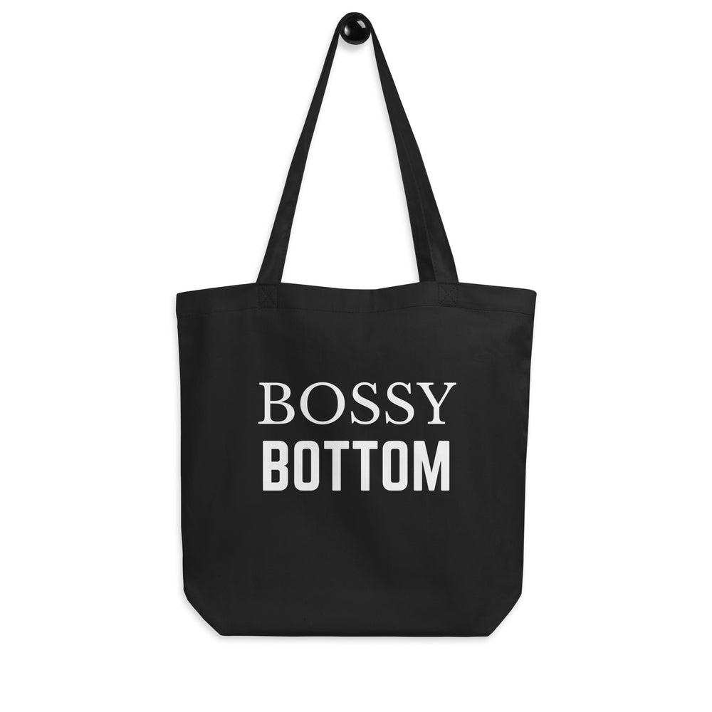 Front-facing black tote bag with white text reading “BOSSY BOTTOM”