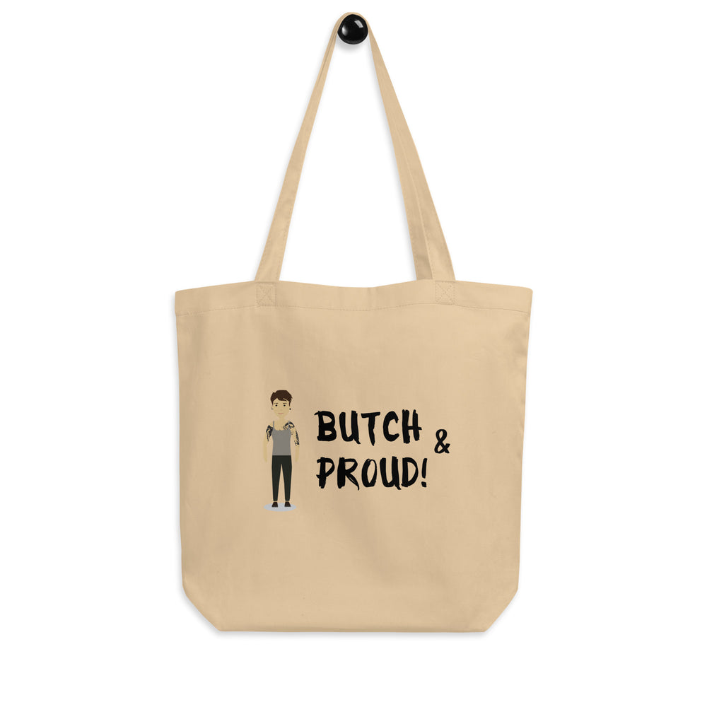 Front view of a tan tote bag reading “BUTCH & PROUD!” beside a butch-style figure