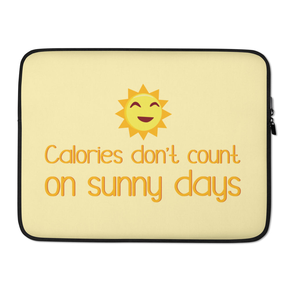 Front view of a pale yellow laptop sleeve with a smiling sun and “Calories don’t count on sunny days”