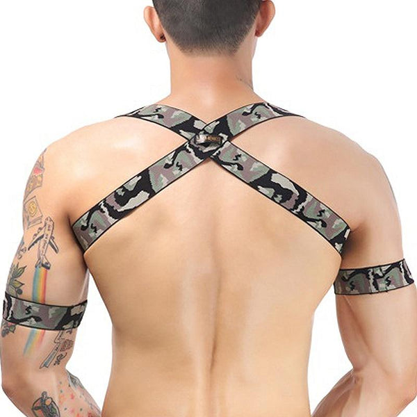 Rear view of a model wearing a camouflage elastic chest harness with crossed back straps and arm bands