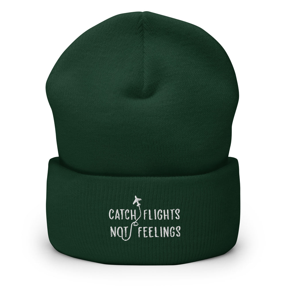 Dark green cuffed beanie with white airplane graphic and “CATCH FLIGHTS NOT FEELINGS” text