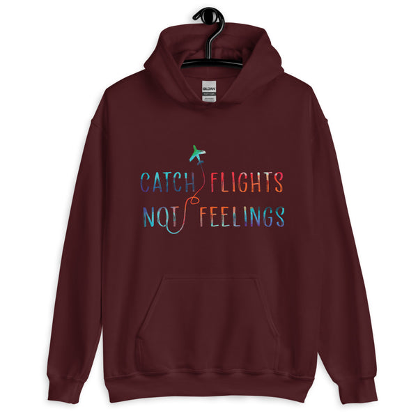 Maroon pullover hoodie on a hanger with colorful “CATCH FLIGHTS NOT FEELINGS” lettering