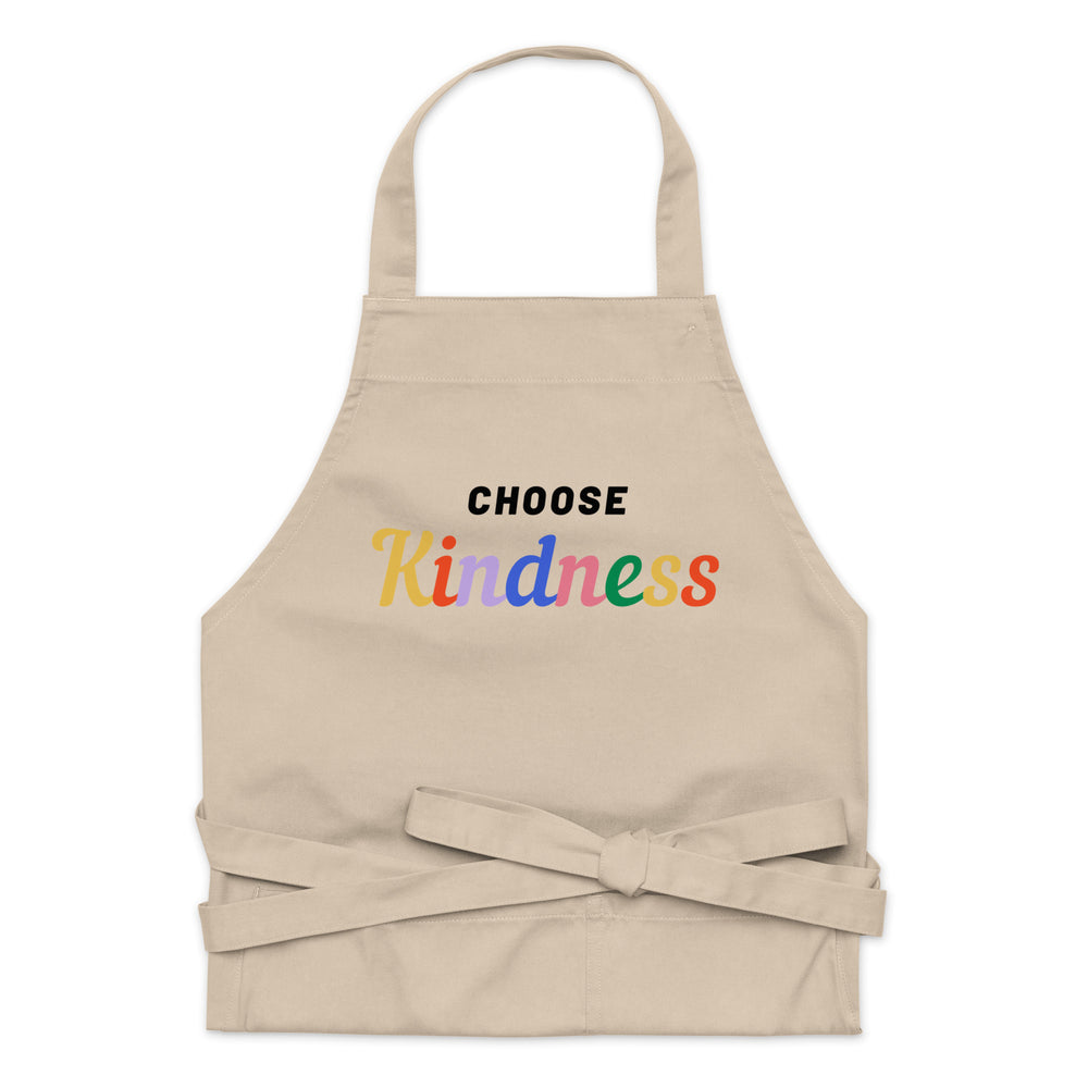 Front-facing beige apron with a neck loop, tied waist straps, and colorful “CHOOSE Kindness” lettering
