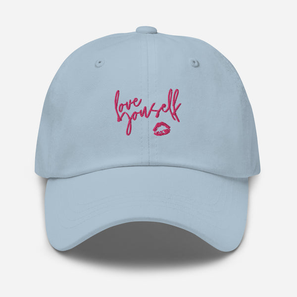 Front view of a light blue cap embroidered with “Love yourself” and a pink lips graphic.