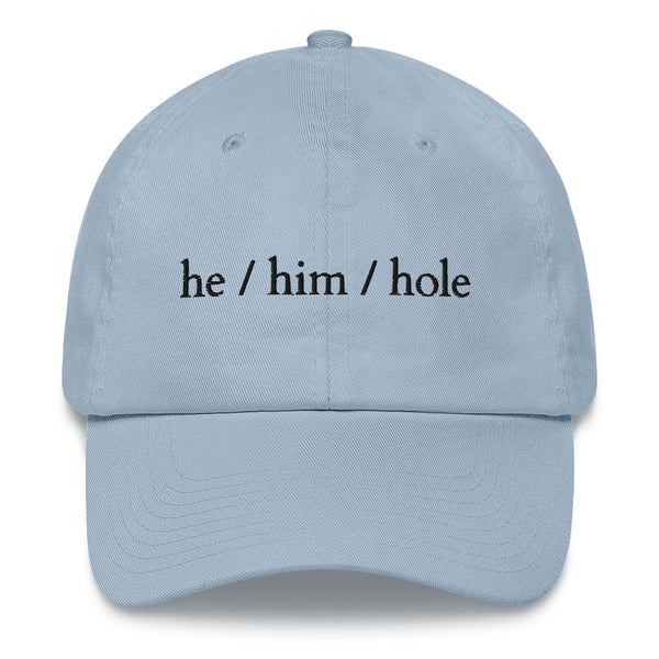 Front view of a light blue cap reading “he / him / hole” in black