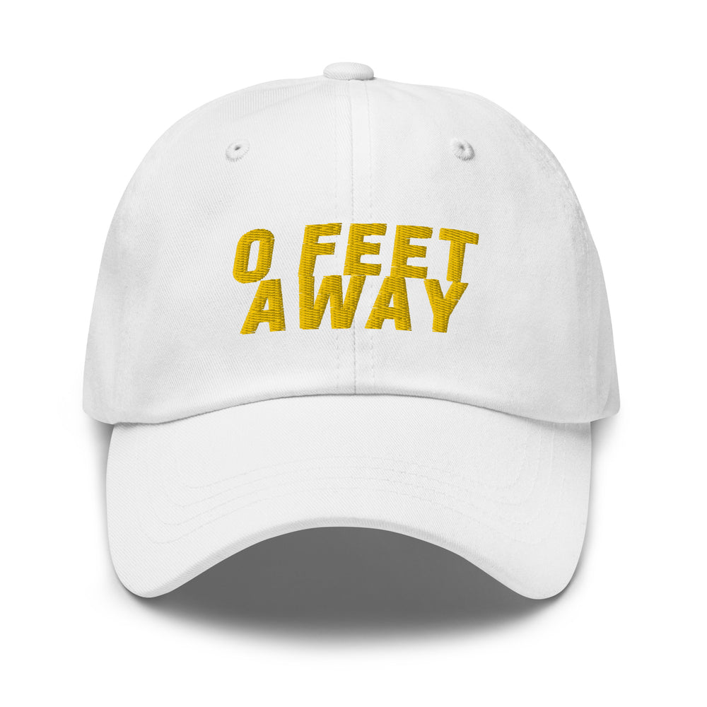 Front view of a white cap embroidered with yellow text reading “0 FEET AWAY”