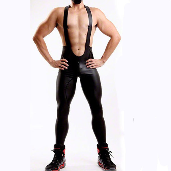 Front-facing shirtless model wearing black faux-leather pants with attached suspenders