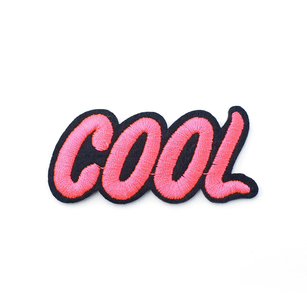 Close-up of a pink embroidered “cool” iron-on patch with black edging