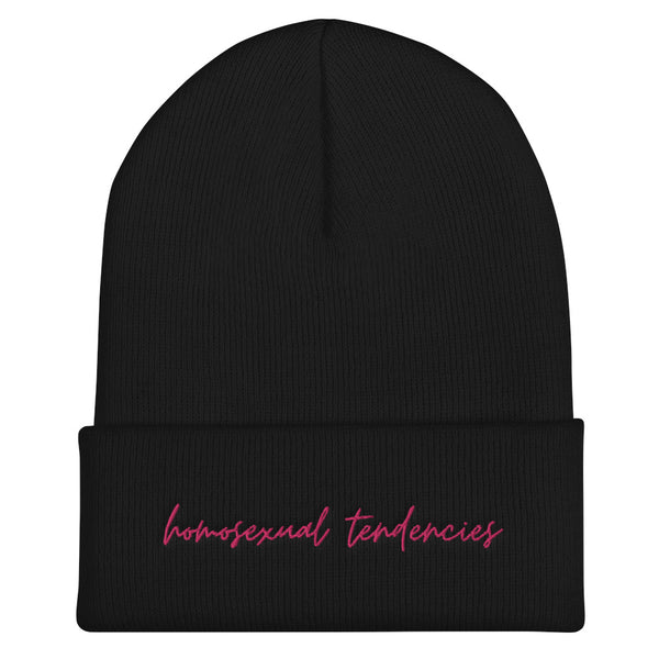 Front view of a black cuffed beanie with pink cursive text, “homosexual tendencies”