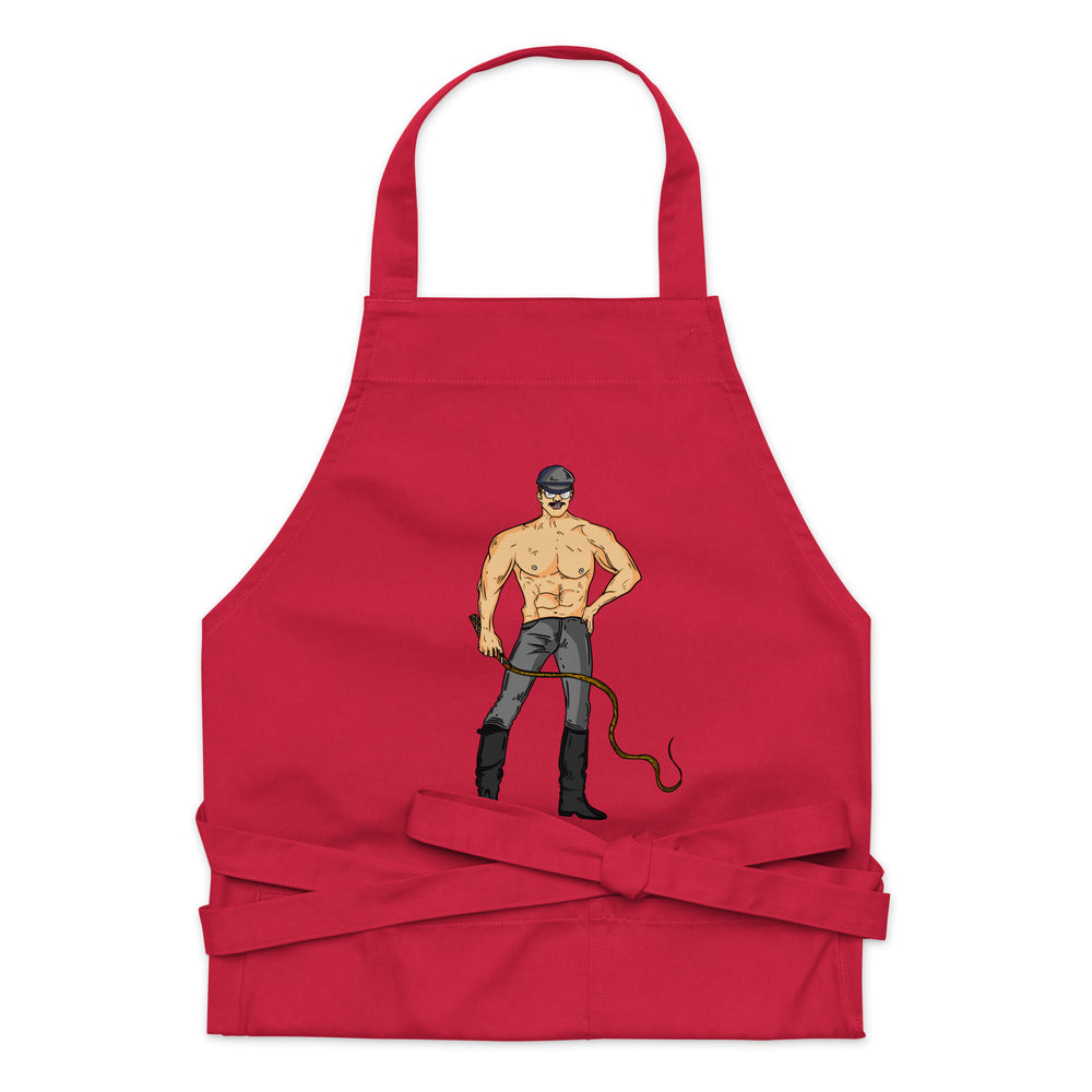 Red apron with neck strap and waist ties, featuring a shirtless mustached man holding a whip