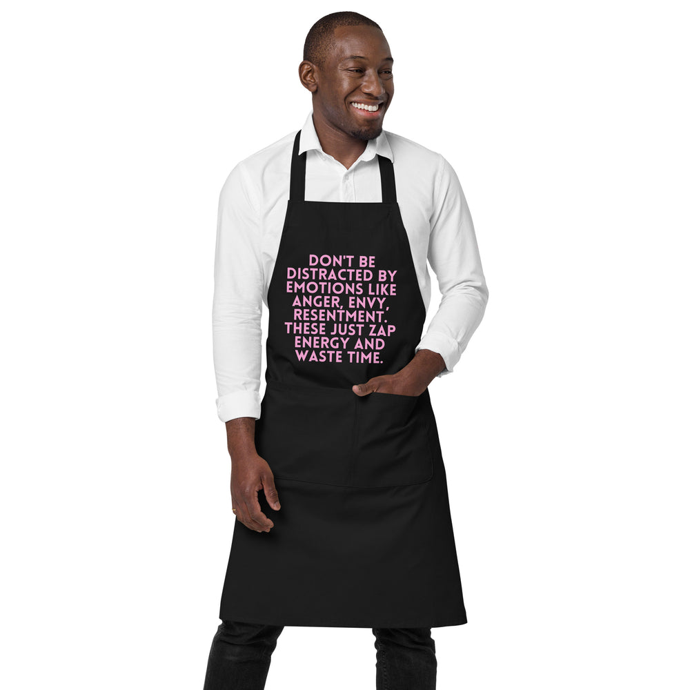 Front view of a model wearing a black apron with pink text and a large front pocket
