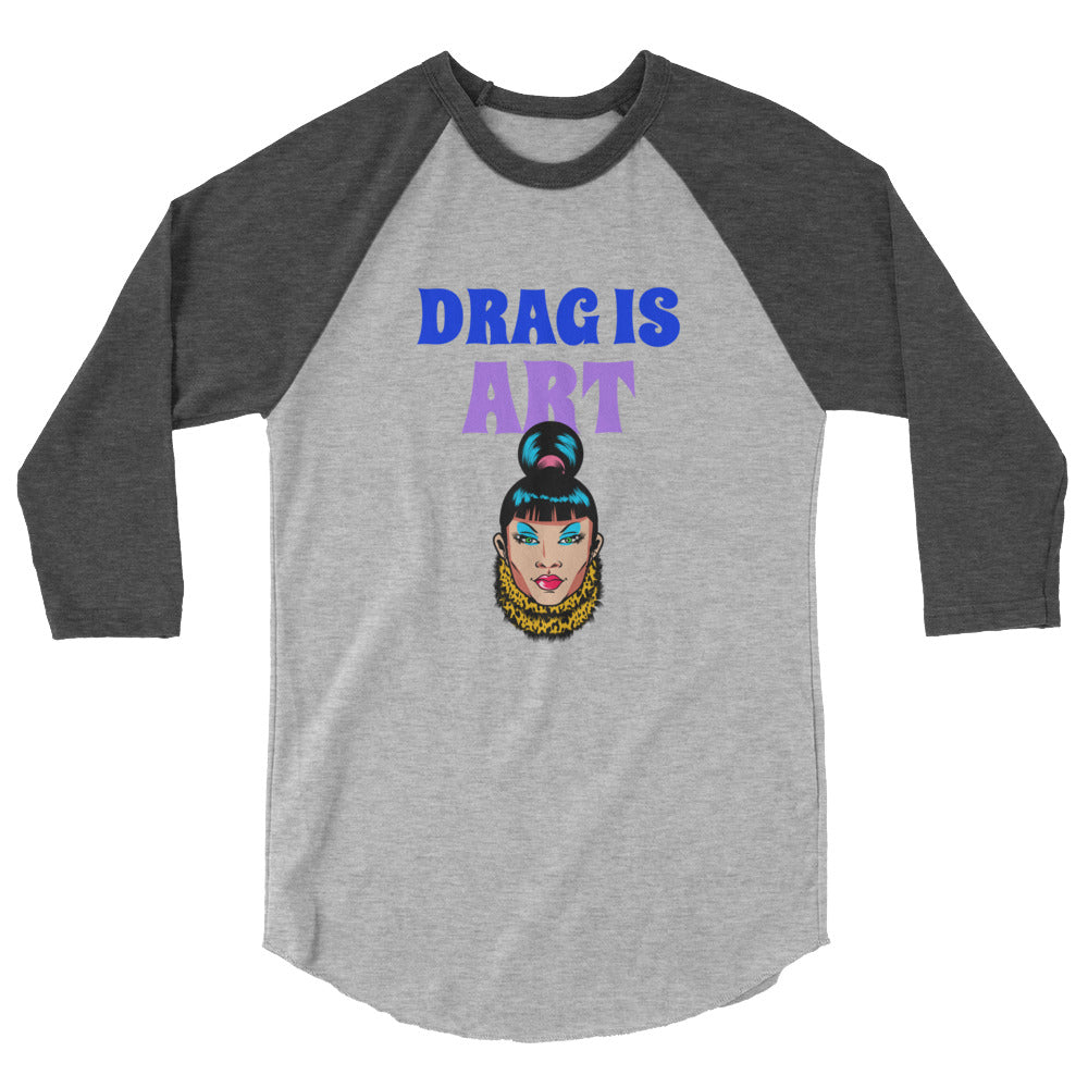 Front view of a gray raglan shirt with dark sleeves reading “DRAG IS ART” above a drag performer illustration
