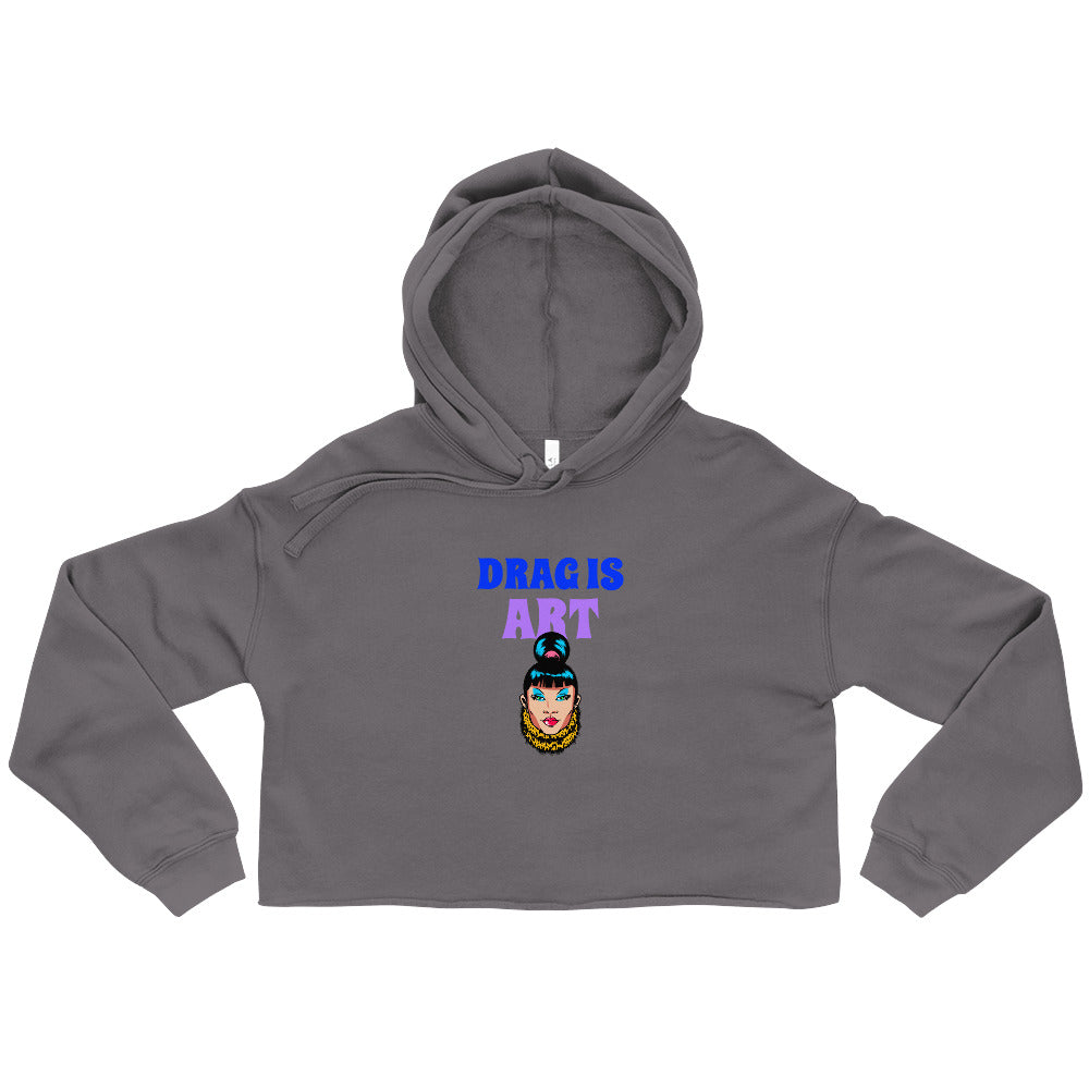 Flat-lay charcoal cropped hoodie reading “DRAG IS ART” above a colorful drag-queen graphic