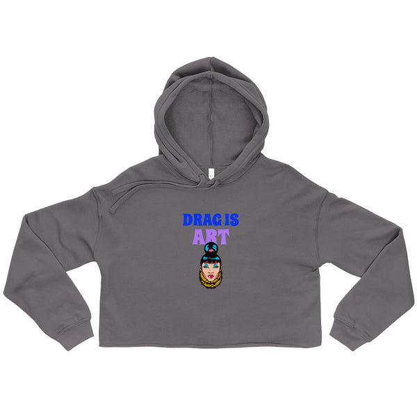 Flat-lay charcoal cropped hoodie reading “DRAG IS ART” above a colorful drag-queen graphic