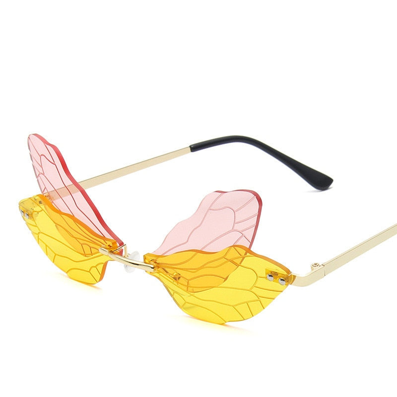 Dragonfly-shaped sunglasses with translucent yellow lenses, pink wings, and gold arms