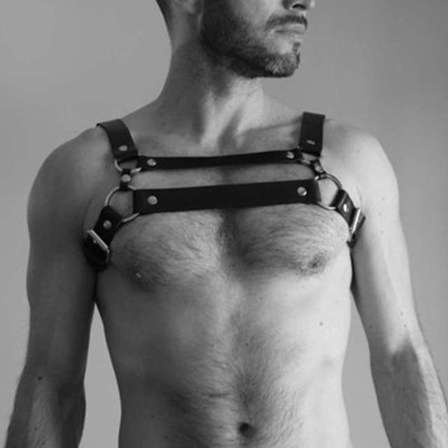 Model wearing a black leather chest harness with double horizontal straps and metal hardware