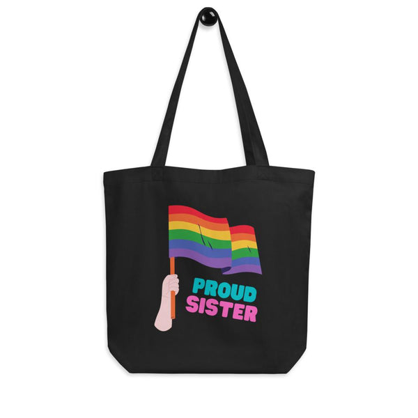 Black tote bag with a rainbow flag graphic and “PROUD SISTER” text