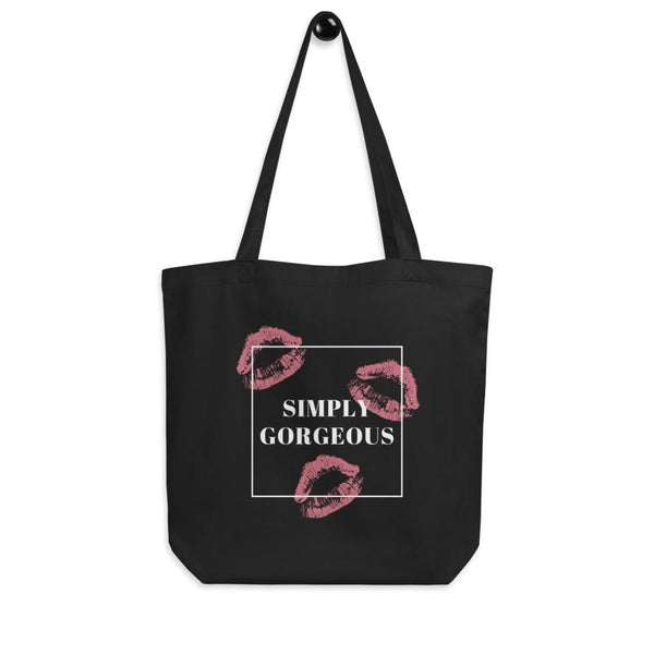 Black tote bag with pink lipstick prints and a white box reading “SIMPLY GORGEOUS”