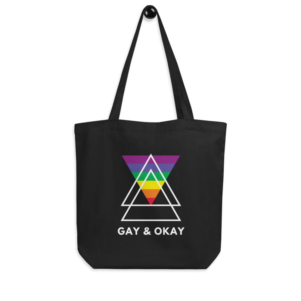 Black tote bag with rainbow triangle graphic and “GAY & OKAY” text