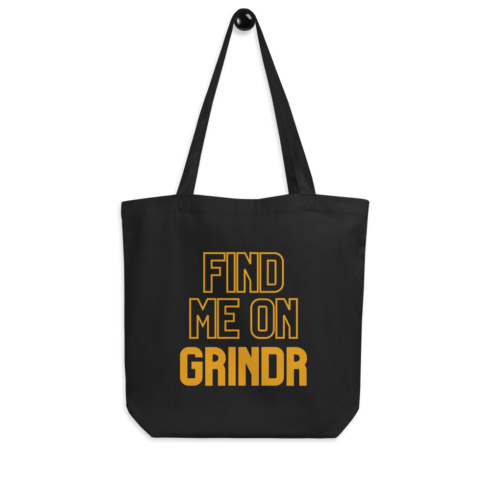 Front view of a black tote bag with gold text reading “FIND ME ON GRINDR.”