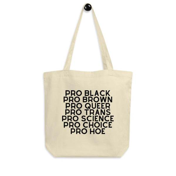 Cream canvas tote bag with black text reading “PRO BLACK PRO BROWN PRO QUEER PRO TRANS PRO SCIENCE PRO CHOICE PRO HOE”