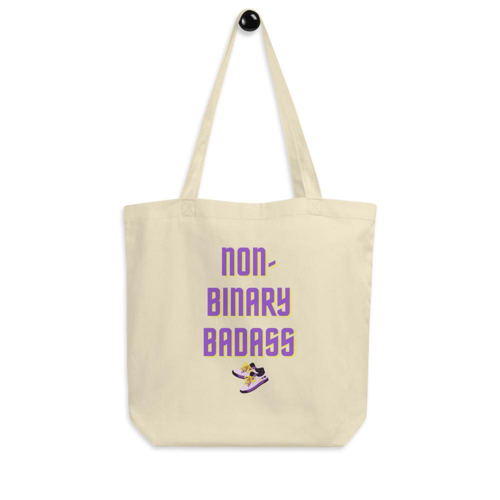 Cream non-binary tote bag with purple and yellow “NON-BINARY BADASS” text and sneaker graphic