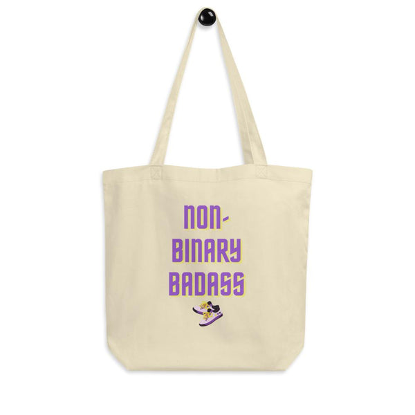 Cream non-binary tote bag with purple and yellow “NON-BINARY BADASS” text and sneaker graphic