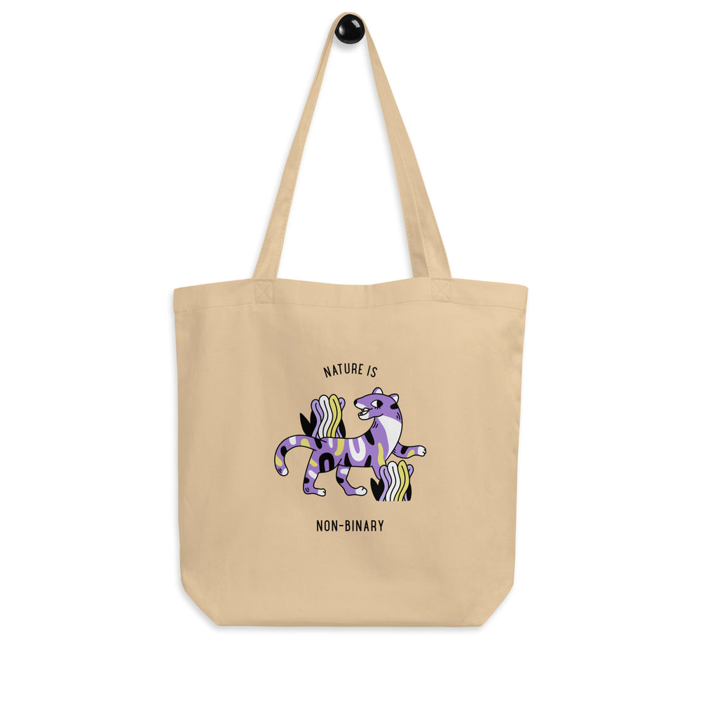 Front view of a beige tote bag reading “NATURE IS NON-BINARY,” with a purple striped animal graphic