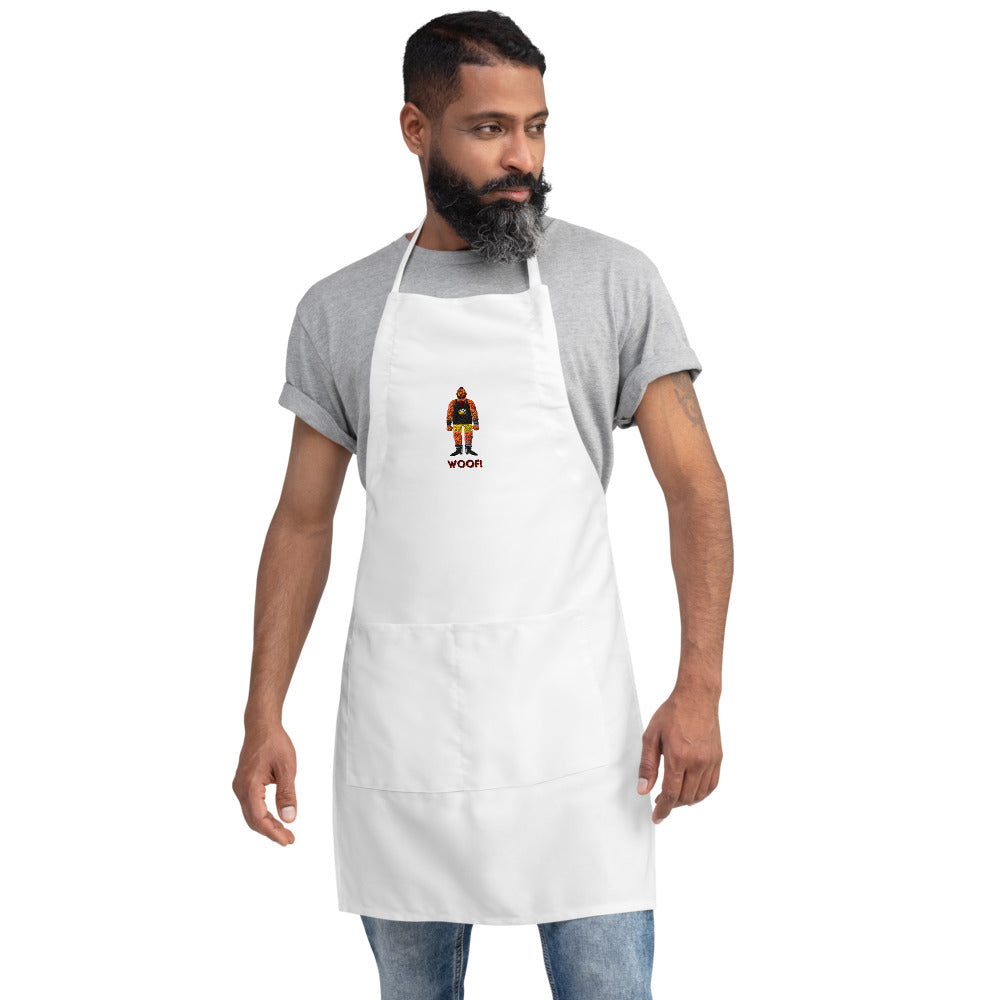 Front-view model wearing a white apron embroidered with a bear and “WOOF!”