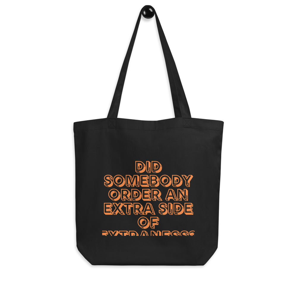 Front view of a black tote bag reading “Did somebody order an extra side of extraness?”