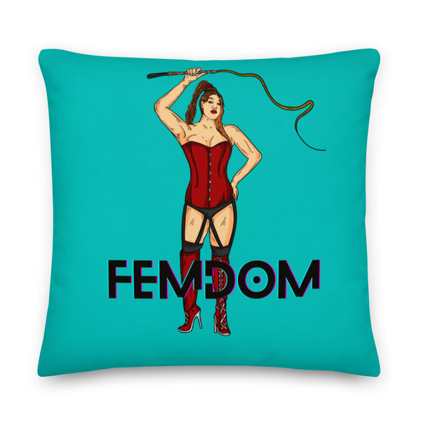 Turquoise pillow featuring a corseted woman holding a riding crop above the word “FEMDOM”