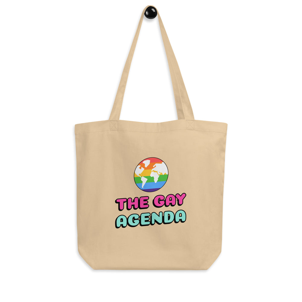 Front view of a natural canvas tote reading “THE GAY AGENDA” with a rainbow globe graphic