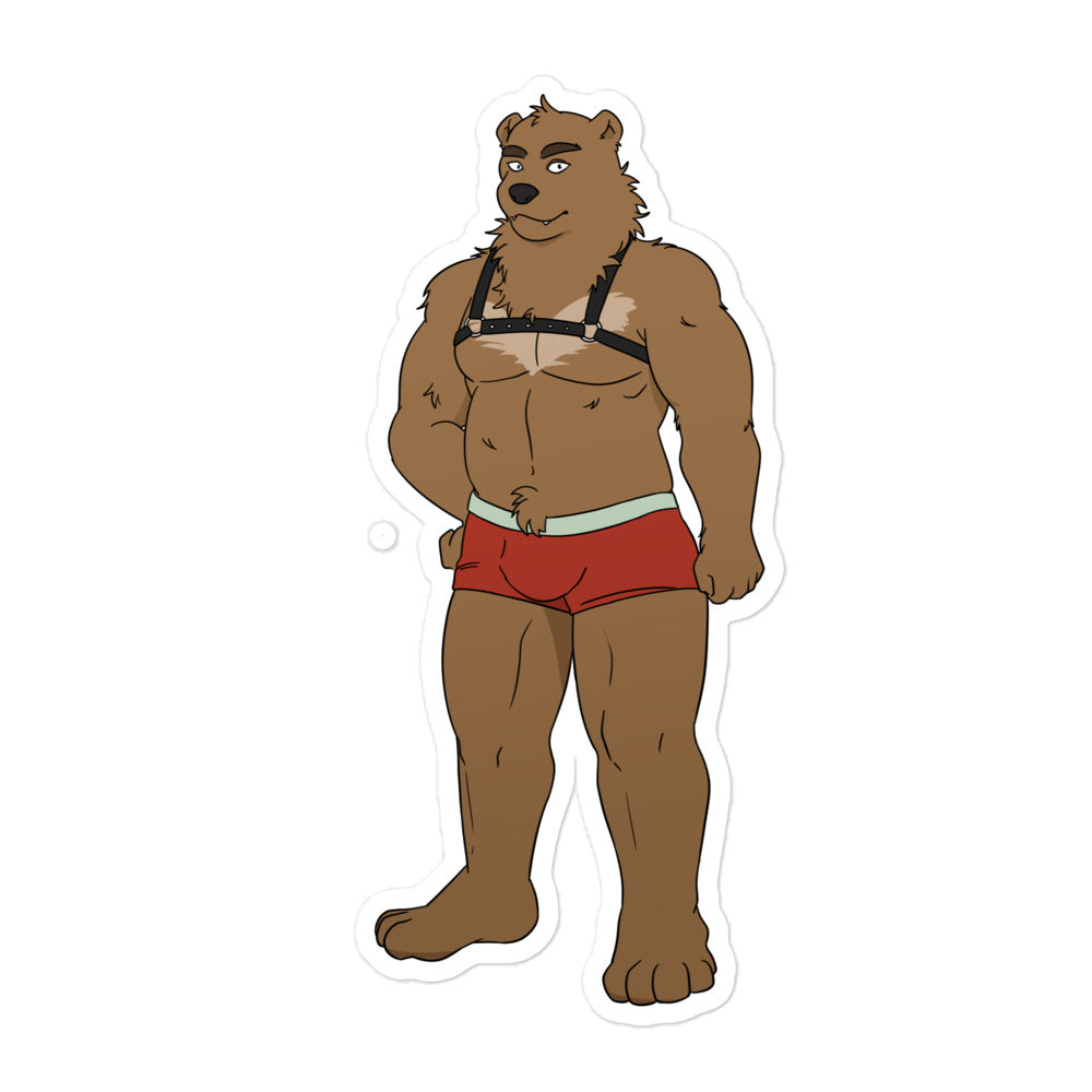 Gay Bear Bubble-Free Sticker with a cartoon bear in red briefs, placed by a bearded man on a black motorcycle gas tank, brick wall behind.