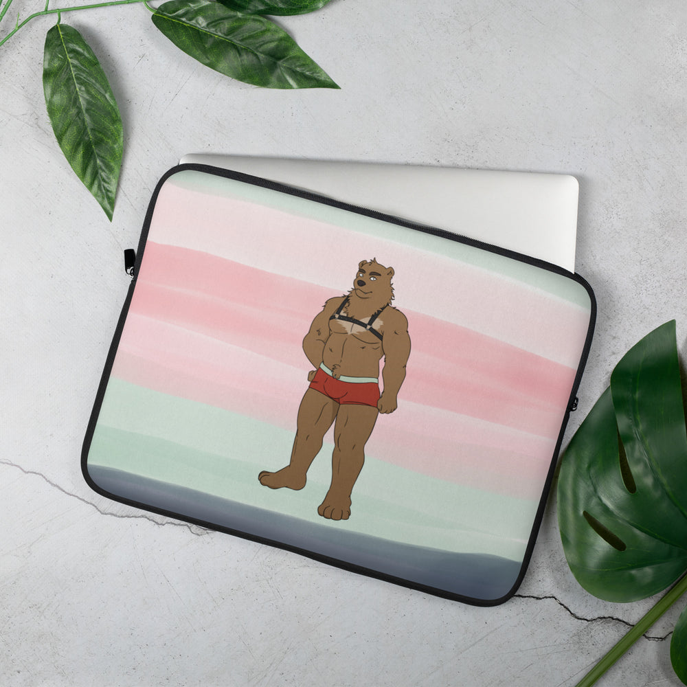 Laptop sleeve angled on a tabletop, featuring a muscular bear in red briefs and a harness