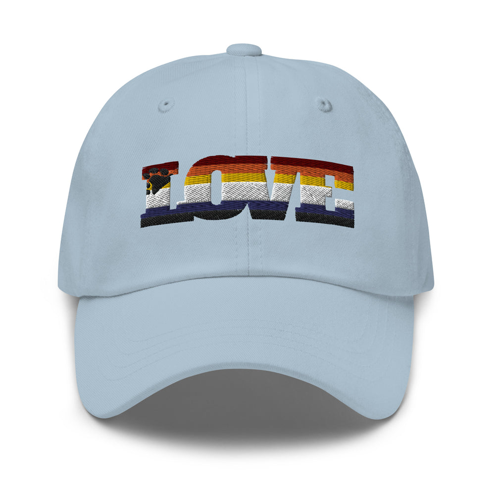 Front view of a light blue cap with embroidered rainbow-striped “LOVE” lettering and bear motif