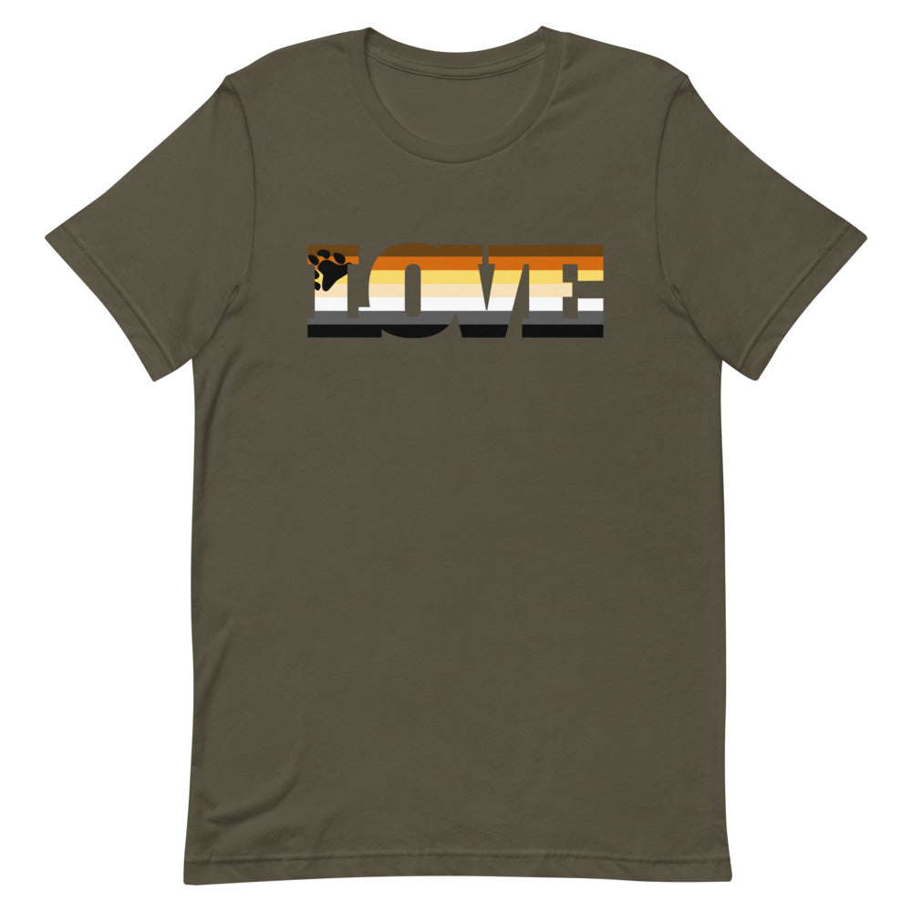 Olive-green Gay Bear Love T-shirt, folded, features bold "LOVE" text and a bear pride paw print in flag colors, on a beige knit blanket.