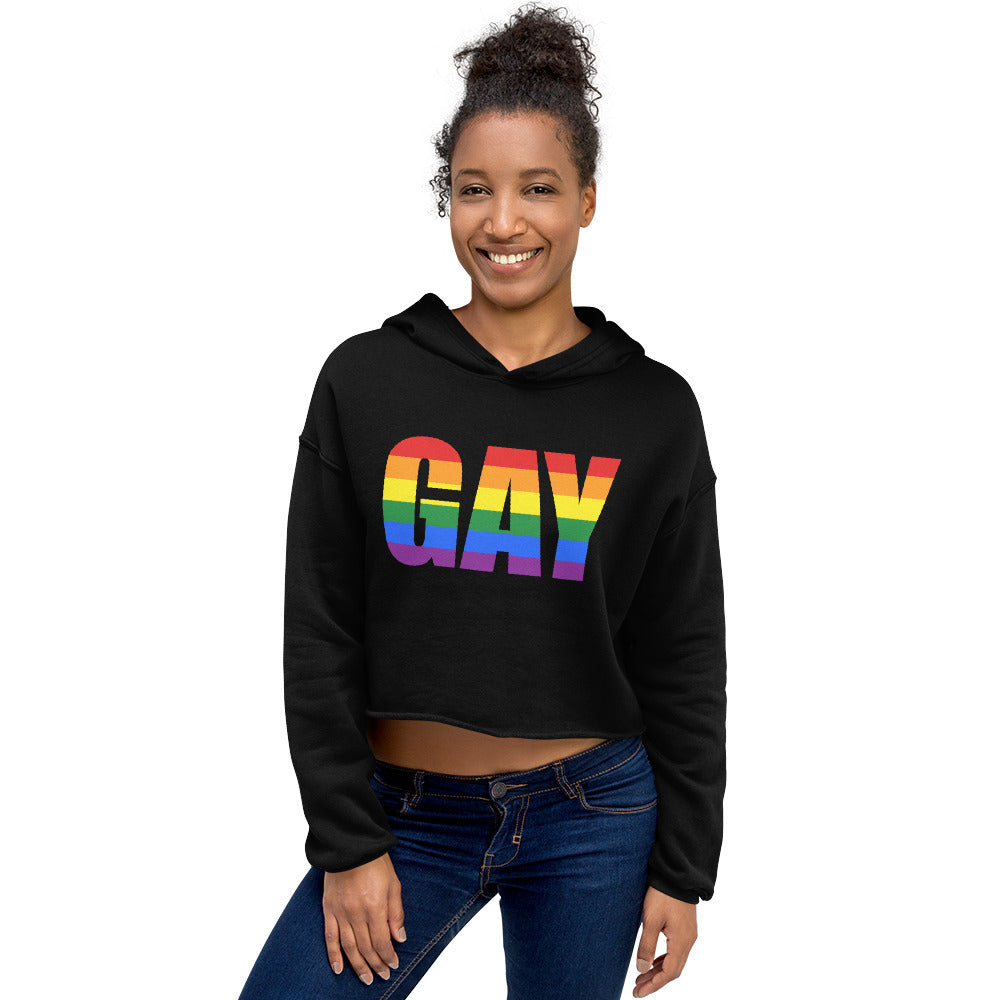 Front-view model wearing a black cropped hoodie with rainbow “GAY” lettering