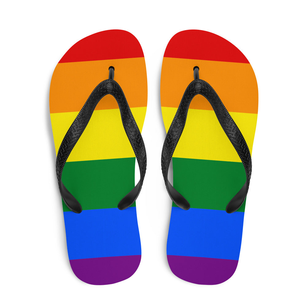 Pair of gay pride flip-flops with rainbow stripes and black textured straps