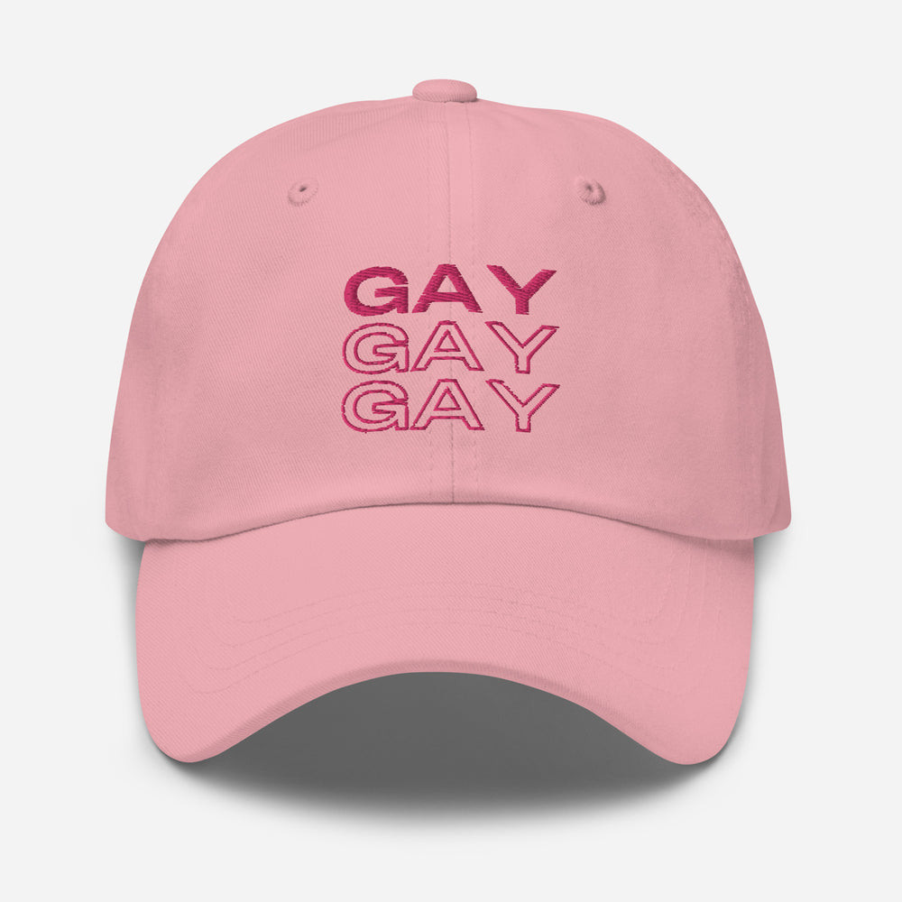 Front view of a pink baseball cap embroidered with “GAY” three times